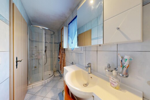 salle de bains avec douche, tile wall, miroir, mur en carrelage, et lavabo (ou coiffeuse selon le contexte)