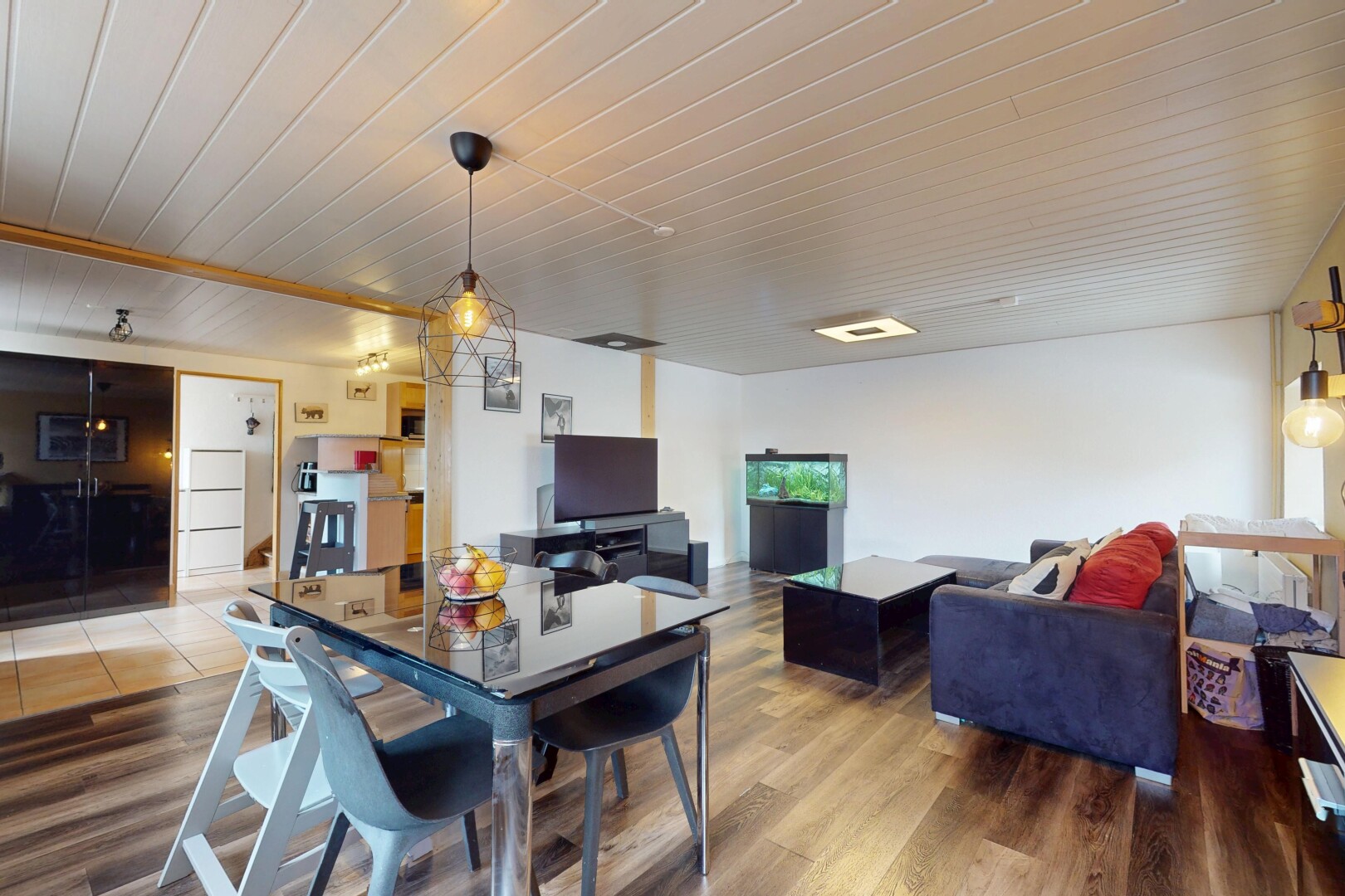 wohn- / esszimmer mit inside property, wood finish floor, holzfußboden, fernseher, und drywall