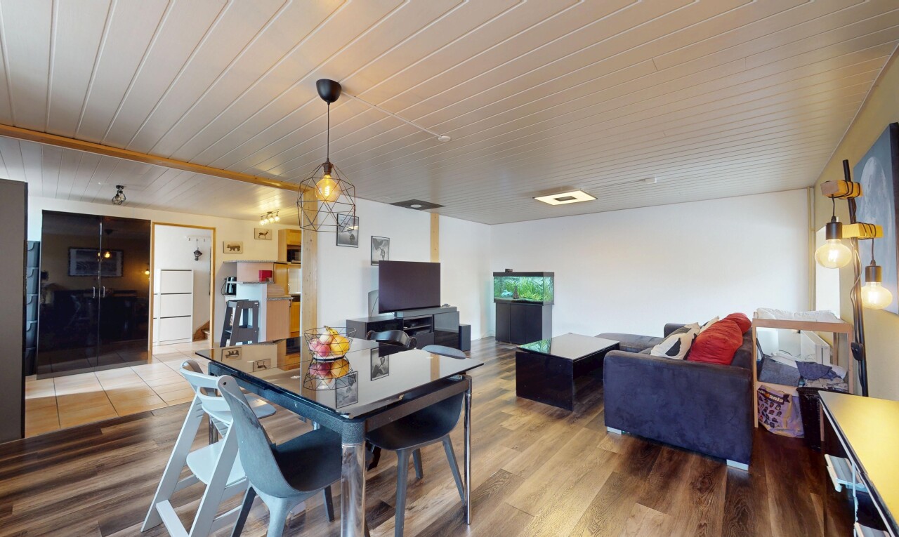 wohn- / esszimmer mit inside property, wood finish floor, holzfußboden, fernseher, und drywall