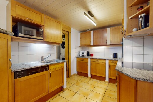 cuisine avec lave-linge et sèche-linge superposés, backsplash, dosseret, lave-vaisselle, et micro-ondes