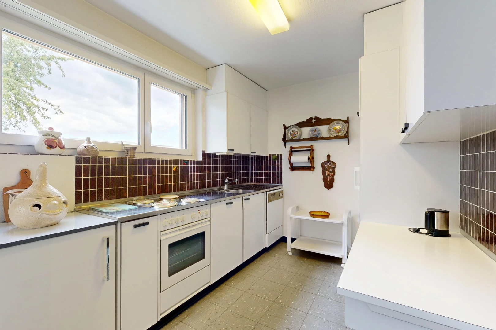 cuisine avec armoires blanches, white cabinets, light floor, plans de travail, et light countertops