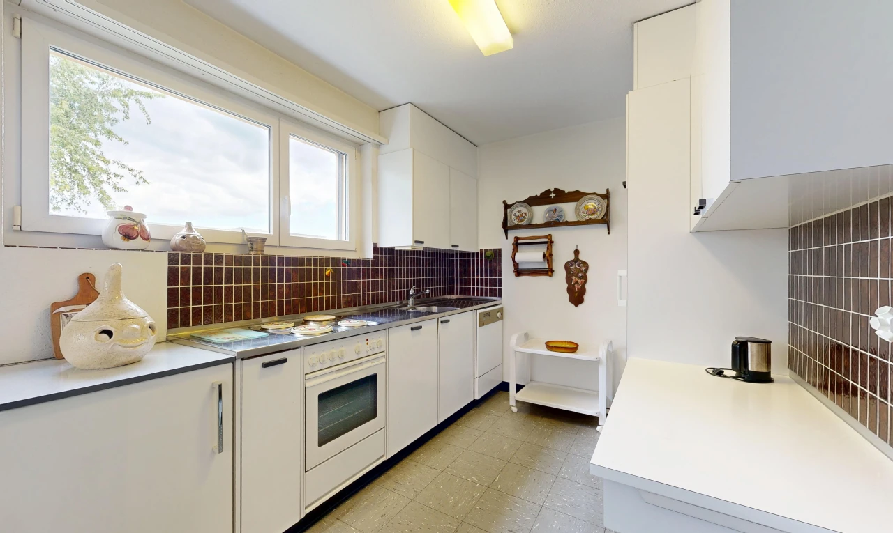 cuisine avec armoires blanches, white cabinets, light floor, plans de travail, et light countertops
