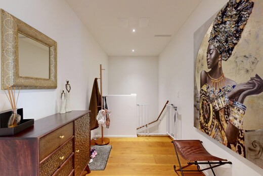 hall with light wood-style floors, recessed lighting, and an upstairs landing