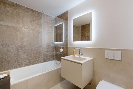 full bath featuring tile walls, tiled shower / bath combo, and vanity