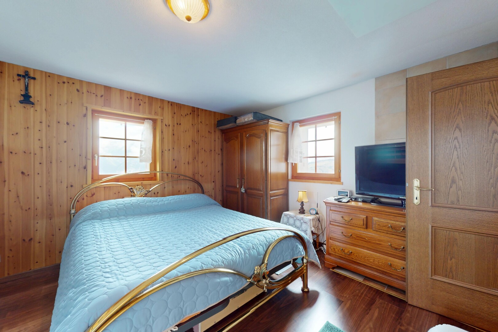 chambre avec sol en finition bois, wood finish floor, lumière naturelle, natural light, et télévision