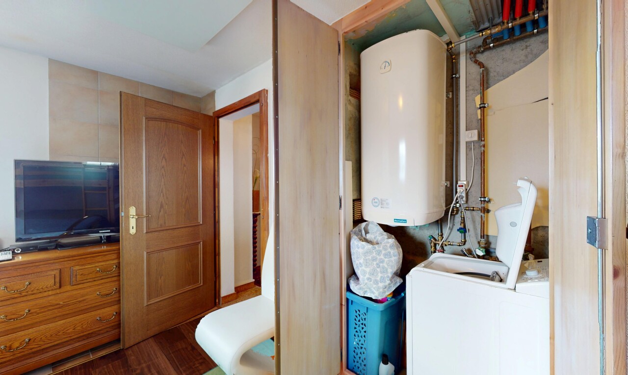 cuisine avec chauffe-eau, wood finish floor, sol en finition bois, inside property, et télévision