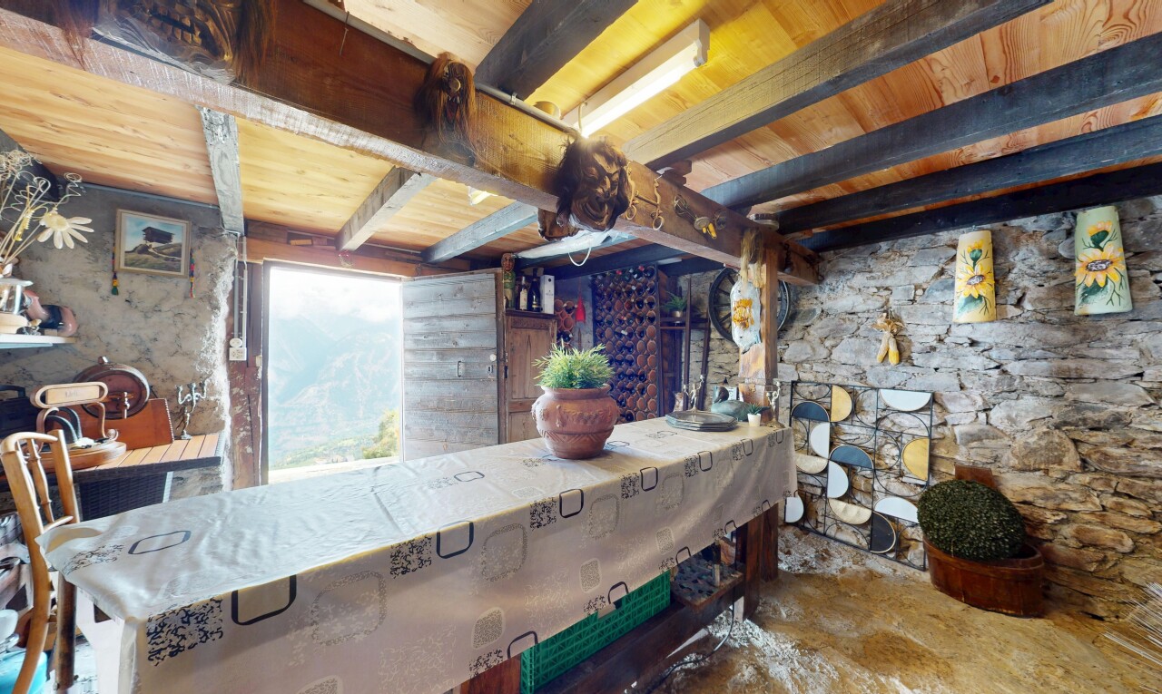 salle à manger avec inside property, beamed ceiling, plafond à poutres, stone wall, et mur en pierre