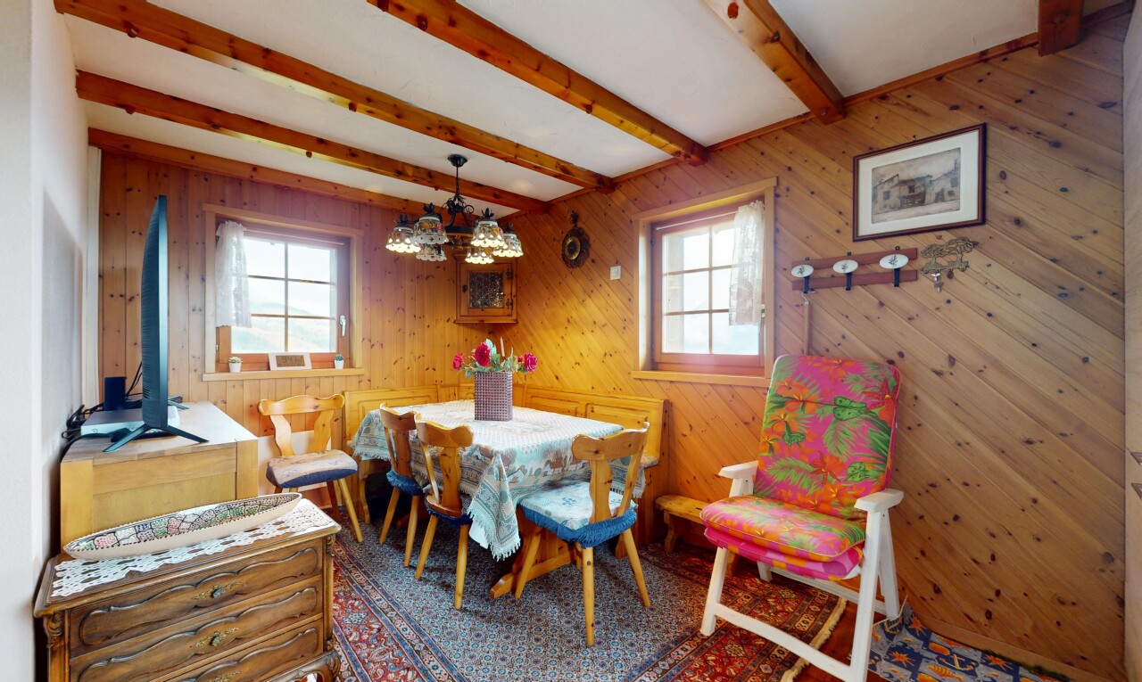 salle à manger avec plafond à poutres, beamed ceiling, mur en bois, lumière naturelle, et wood wall