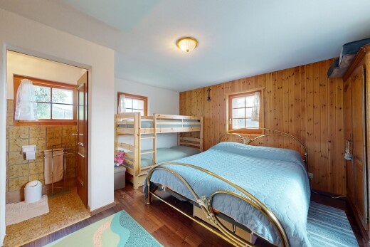 zimmer / schlafzimmer mit natural light, natürliches licht, wood finish floor, holzfußboden, und wood wall