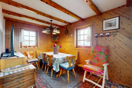 salle à manger avec plafond à poutres, beamed ceiling, mur en bois, lumière naturelle, et wood wall
