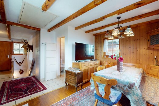 esszimmer mit wood finish floor, holzfußboden, fernseher, beamed ceiling, und balkendecke