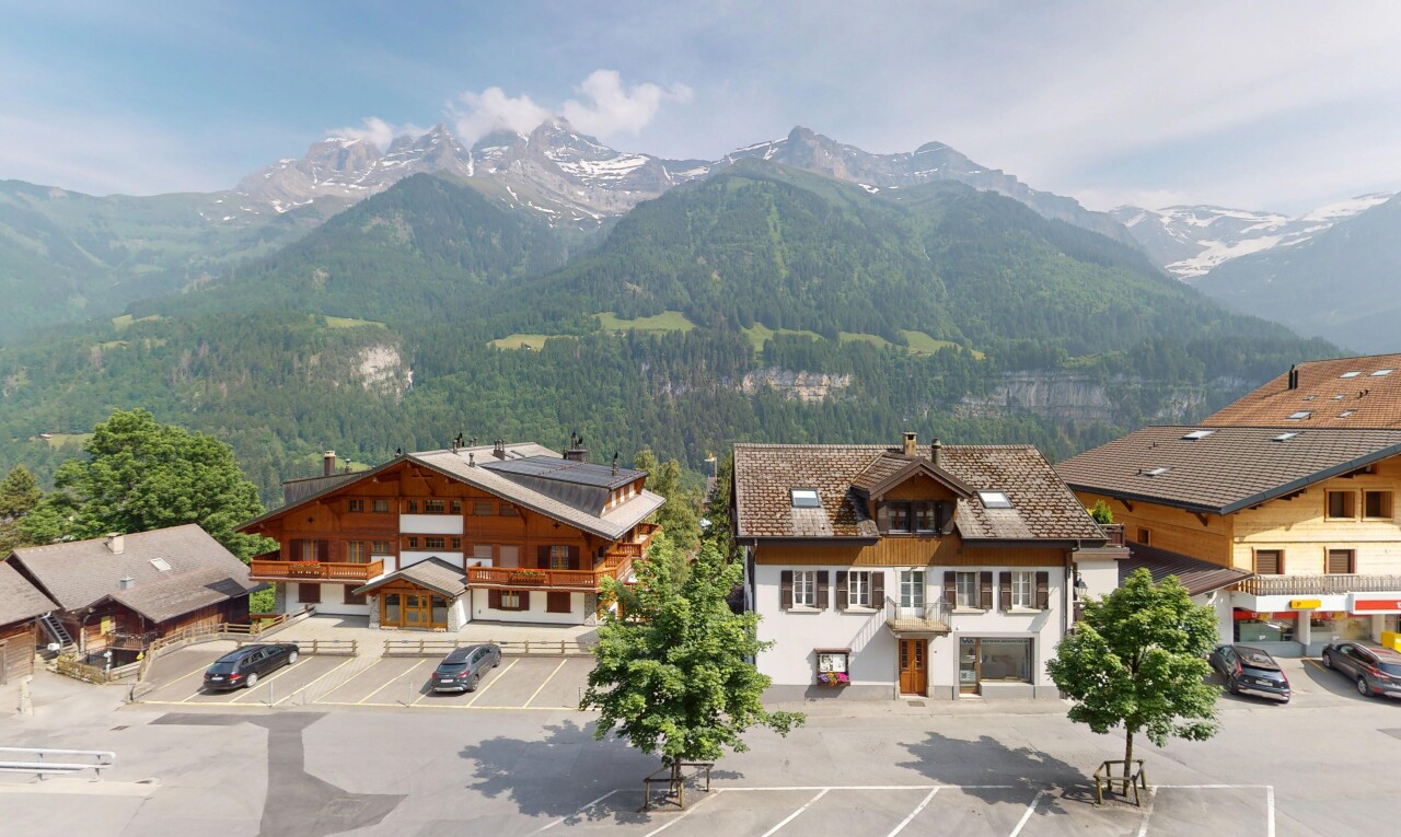 view of property with a mountain view, uncovered parking, and a forest view