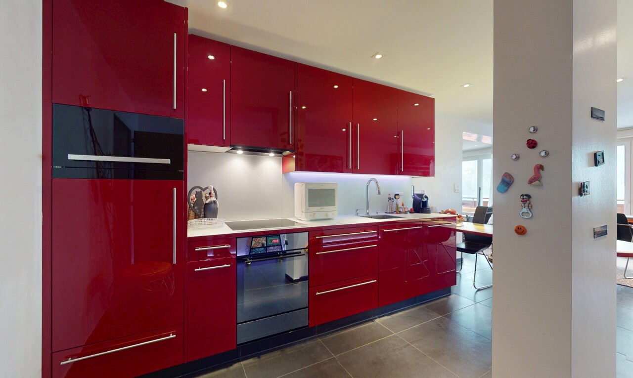 kitchen with red cabinets, wall oven, black electric stovetop, dark tile patterned floors, and light countertops