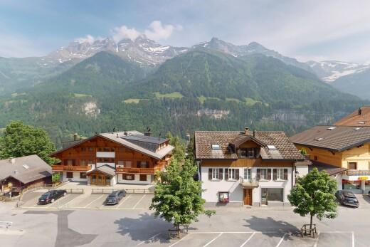 façade avec vue sur la montagne, mountain view, day time, parking, et property visible