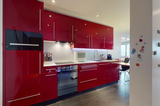 kitchen with red cabinets, wall oven, black electric stovetop, dark tile patterned floors, and light countertops