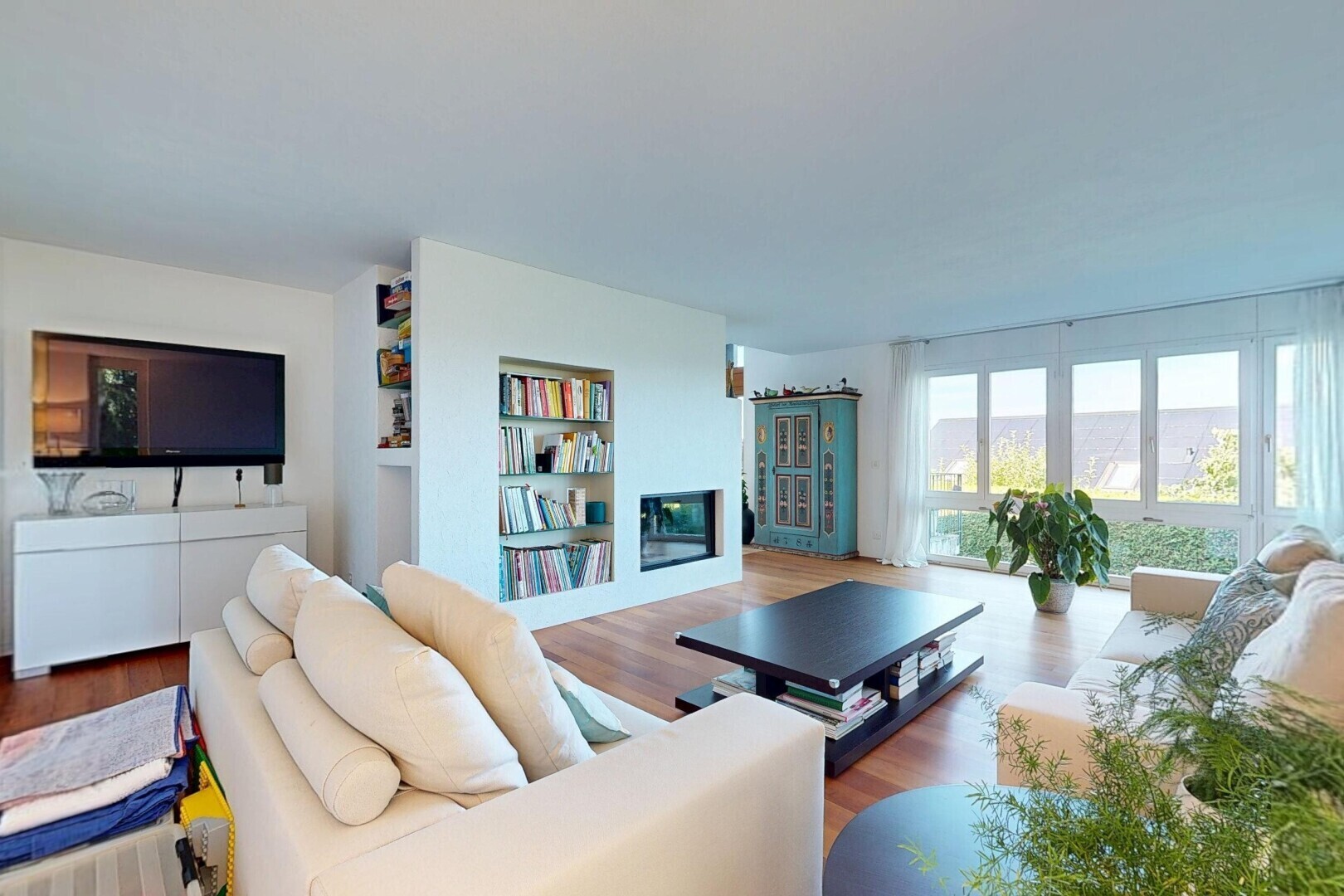 wohnzimmer mit fernseher, inside property, holzfußboden, wood finish floor, und natürliches licht