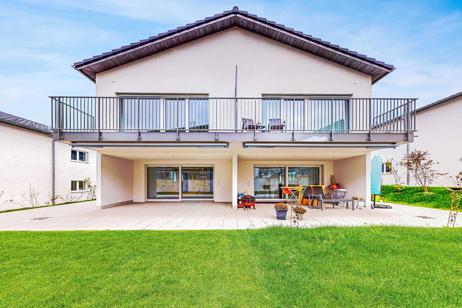 view of property with a patio area, a balcony, and a yard