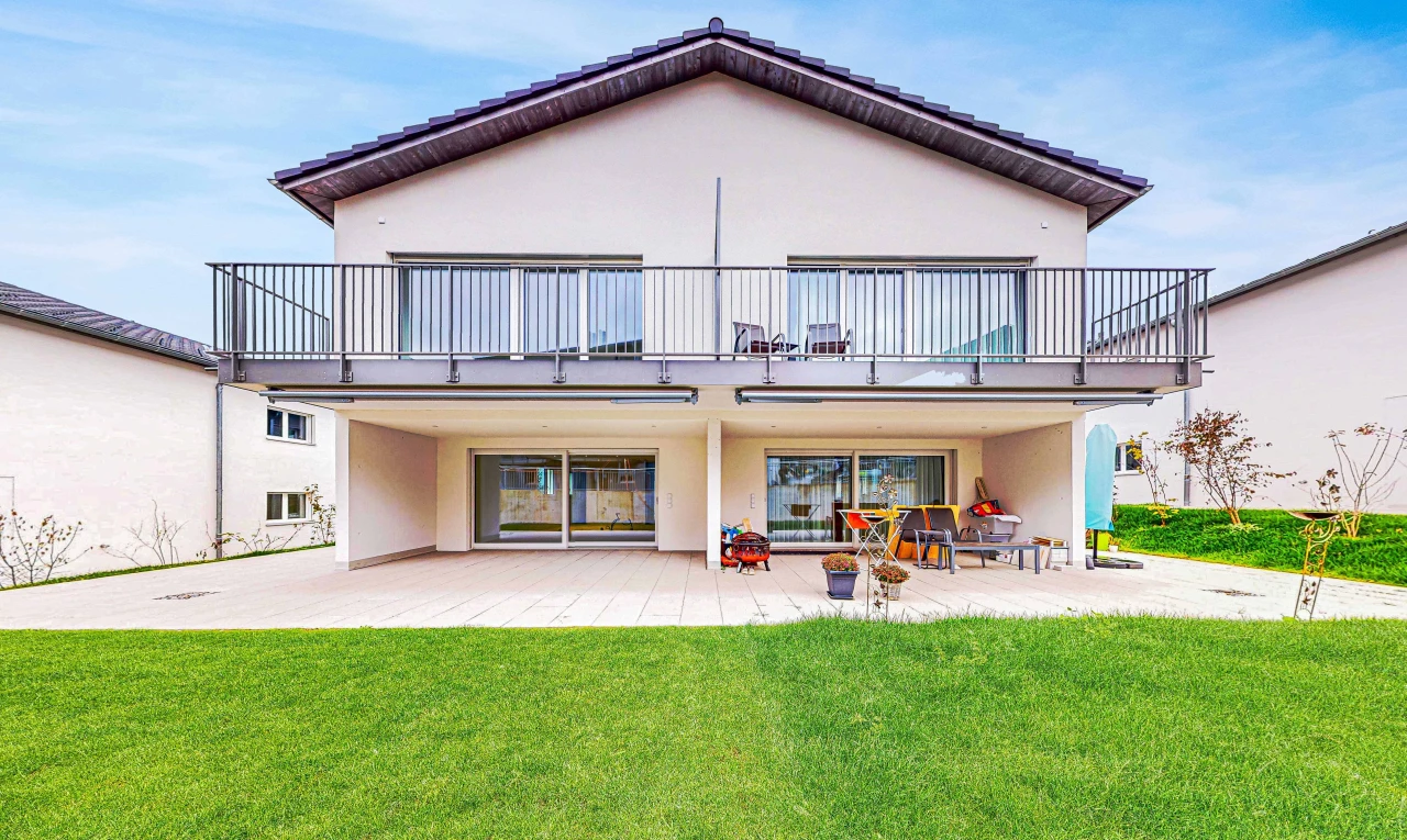 view of property with a patio area, a balcony, and a yard