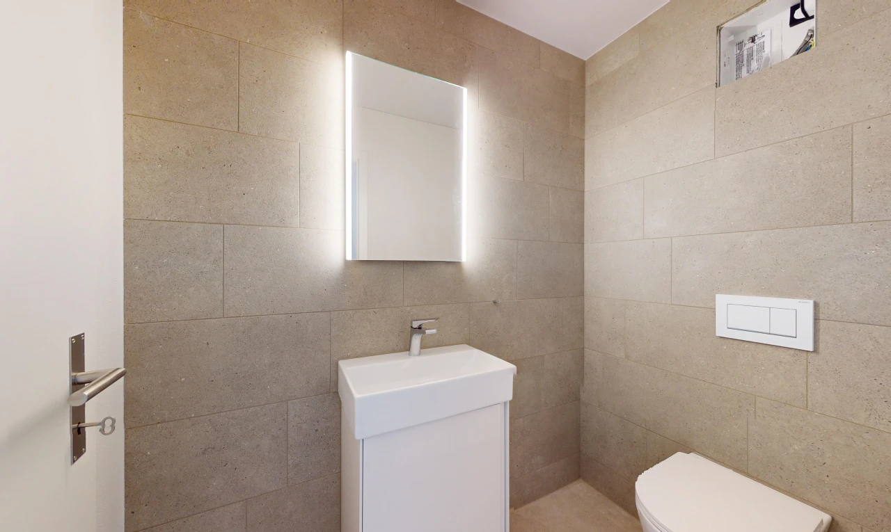 bathroom featuring vanity, toilet, and tile walls