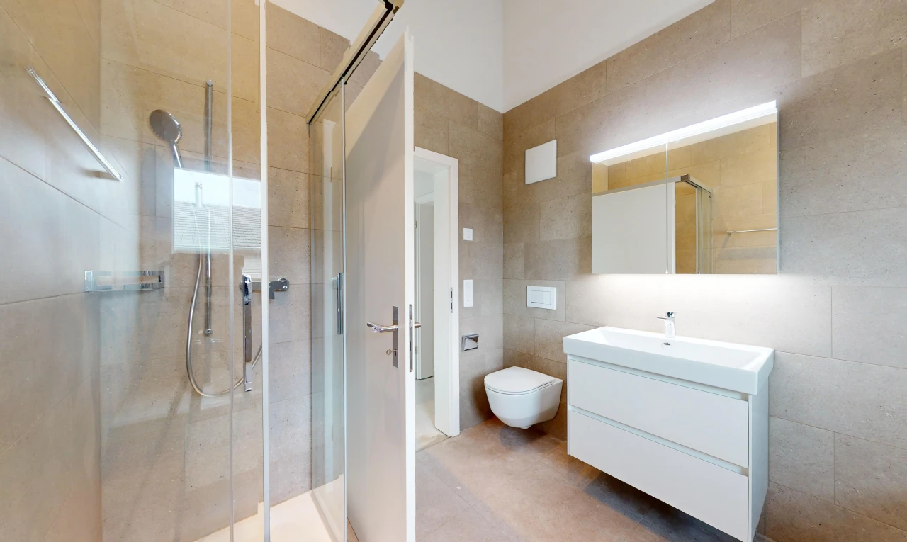bathroom with vanity, toilet, a shower with door, and tile walls