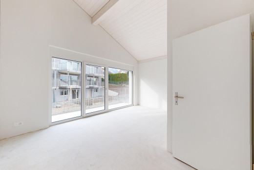 pièce vide avec moquette, haut plafond, lumière naturelle, plafond voûté, et poutres apparentes