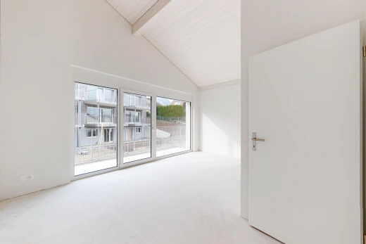 leerer raum mit balkendecke, hohe decke, dachschräge, natürliches licht, und teppich