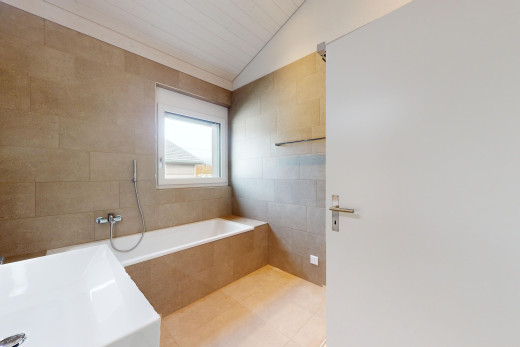 salle de bains avec lumière naturelle, plafond voûté, douche, baignoire, et mur carrelé