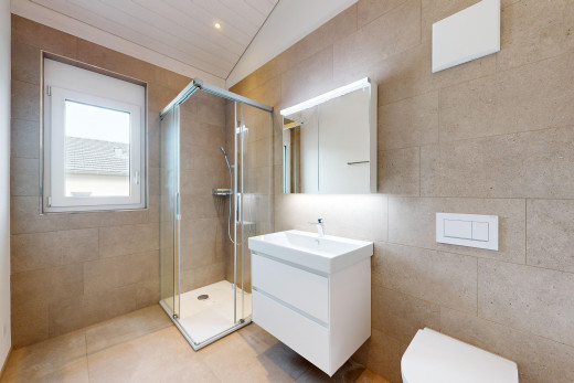 salle de bains avec plafond voûté, carrelage, meuble-lavabo, lumière naturelle, et douche