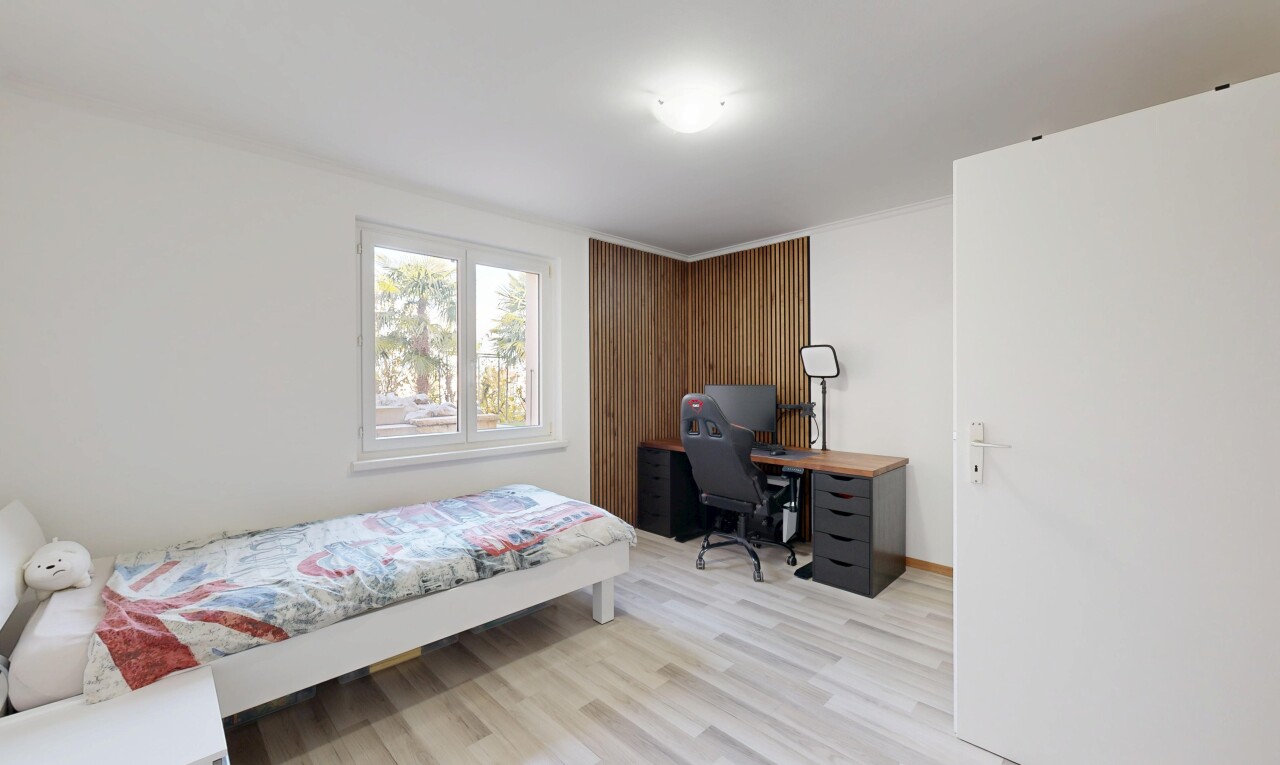 chambre avec cloison sèche, drywall, sol en finition bois, wood finish floor, et lumière naturelle