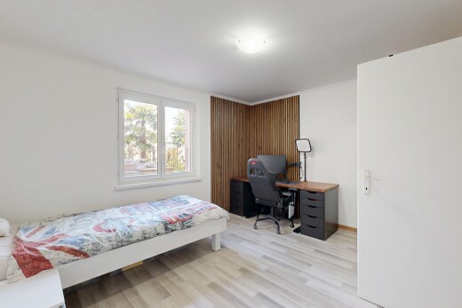 chambre avec cloison sèche, drywall, sol en finition bois, wood finish floor, et lumière naturelle
