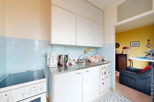 cuisine avec cuisinière, armoires blanches, drywall, cloison sèche, et inside property