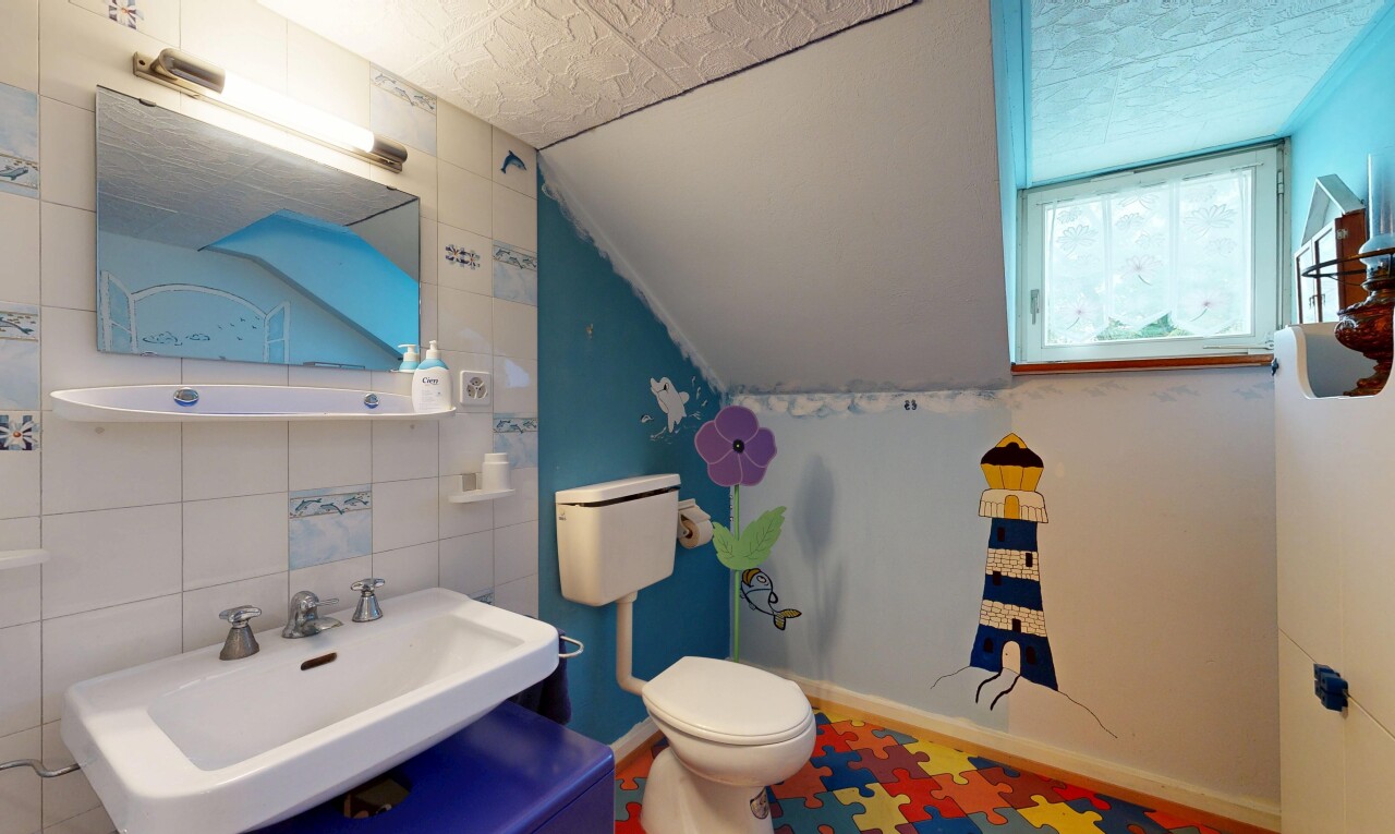 salle de bains avec tile wall, mur en carrelage, miroir, inside property, et toilette