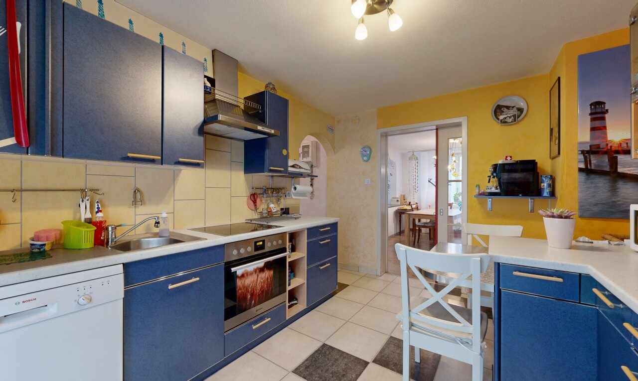 cuisine avec armoires bleues, lave-vaisselle, plans de travail, inside property, et backsplash