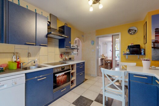 küche mit blaue schränke, geschirrspülmaschine, arbeitsplatten, inside property, und küchenrückwand beim Herd