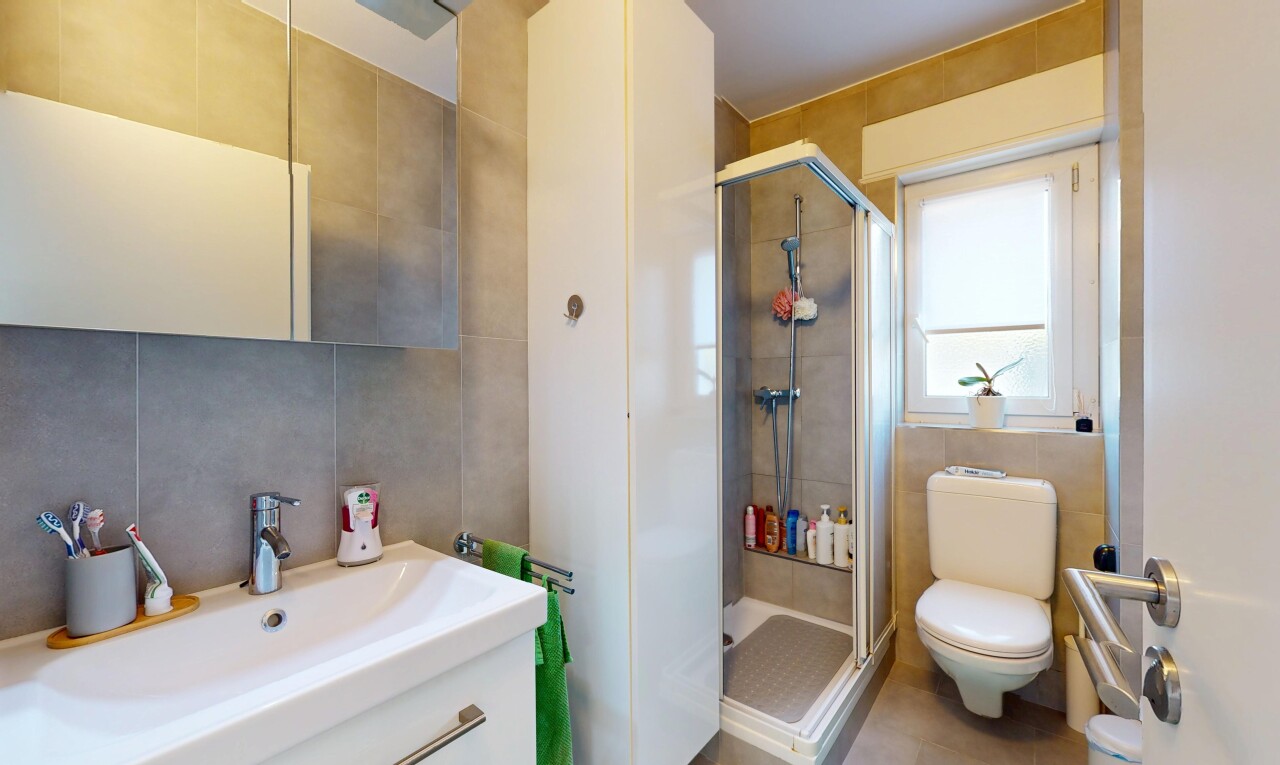 bathroom with vanity, a stall shower, toilet, and tile walls