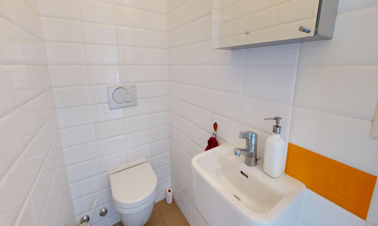 salle de bains avec toilette, évier, inside property, mur en carrelage, et tile wall