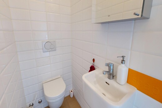 salle de bains avec toilette, évier, inside property, mur en carrelage, et tile wall