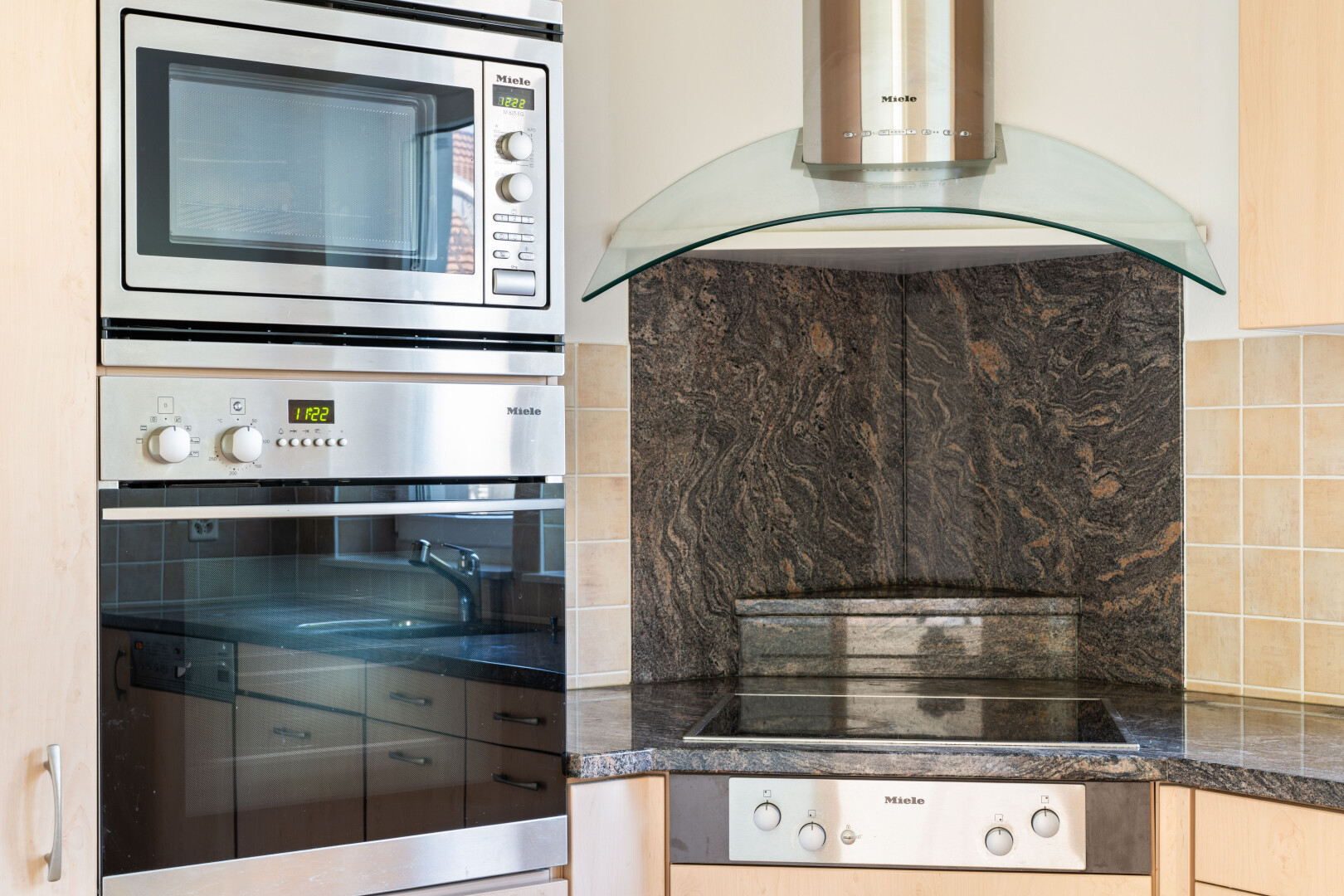 küche mit dunstabzugshaube, ofen, dark countertops, mikrowelle, und inside property