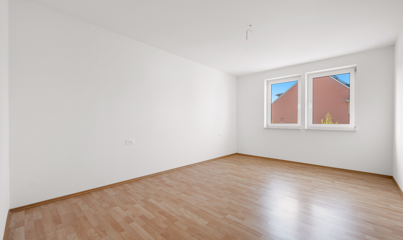 pièce vide avec wood finish floor, sol en finition bois, natural light, lumière naturelle, et drywall