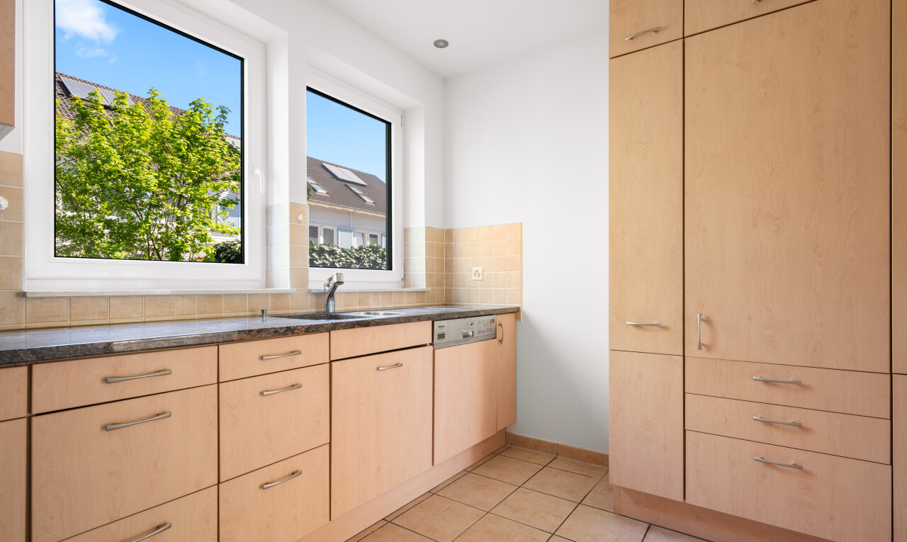 cuisine avec light brown cabinets, armoires marron clair, drywall, cloison sèche, et day time