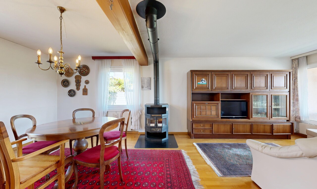 wohn- / esszimmer mit holzofen, drywall, gipskartonwand, wood finish floor, und holzfußboden