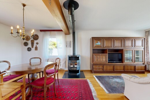 wohn- / esszimmer mit holzofen, drywall, gipskartonwand, wood finish floor, und holzfußboden