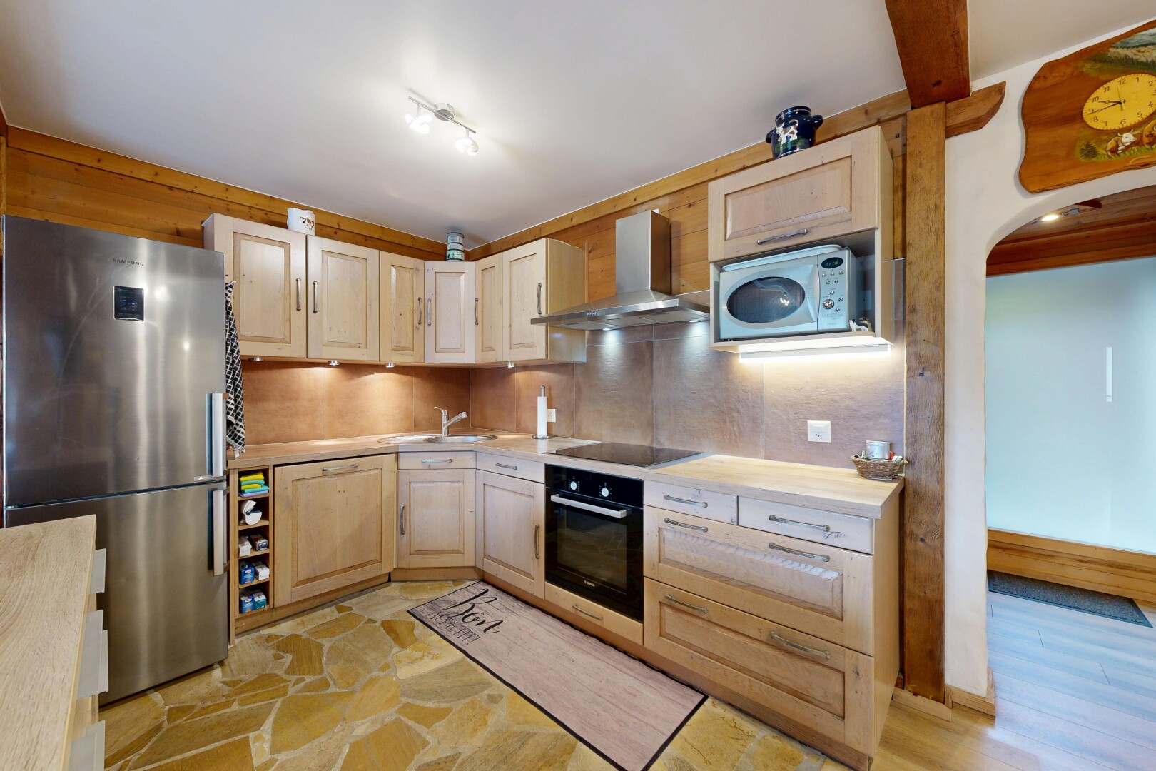 cuisine avec réfrigérateur, armoires élevées, hotte, plans de travail, et inside property