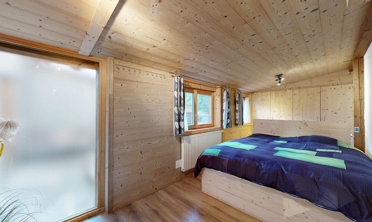 chambre avec wood finish floor, sol en finition bois, wood wall, mur en bois, et inside property