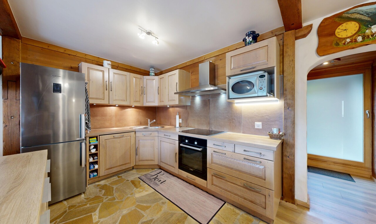 cuisine avec réfrigérateur, armoires élevées, hotte, plans de travail, et inside property