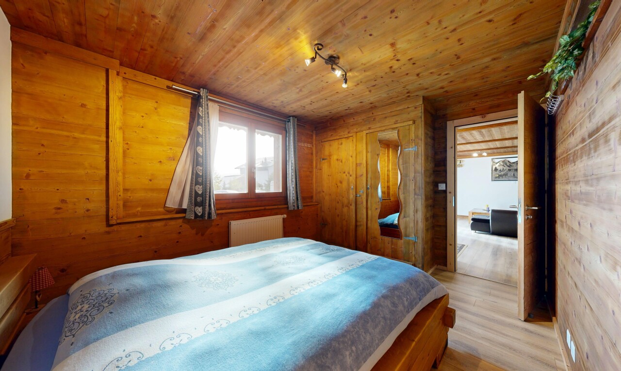 chambre avec inside property, radiateur, sol en finition bois, mur en bois, et wood finish floor