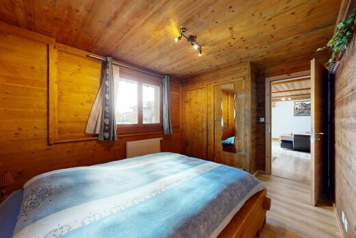 chambre avec inside property, radiateur, sol en finition bois, mur en bois, et wood finish floor