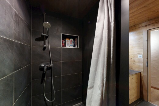 salle de bains avec salle de bain complète, douche, inside property, mur en bois, et wood wall