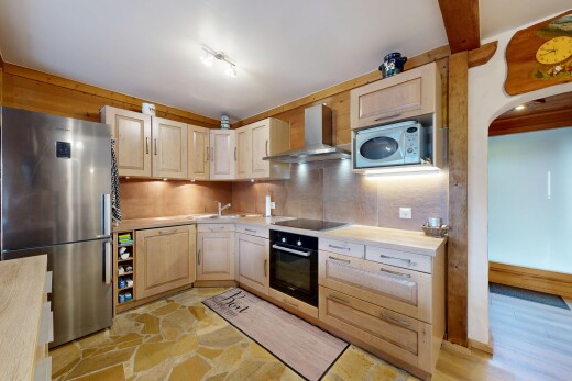 küche mit kühlschrank, hochgezogene schränke, dunstabzugshaube, arbeitsplatten, und inside property