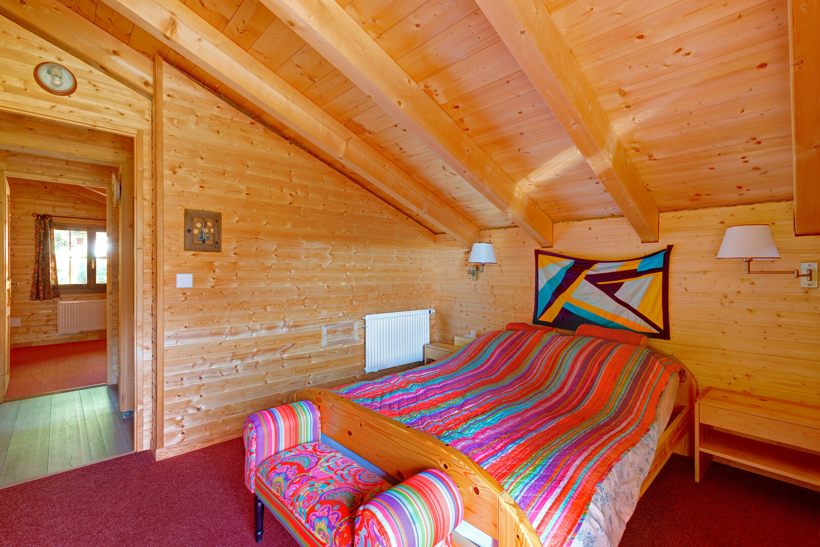 chambre avec vaulted ceiling, plafond voûté, wood wall, mur en bois, et beamed ceiling